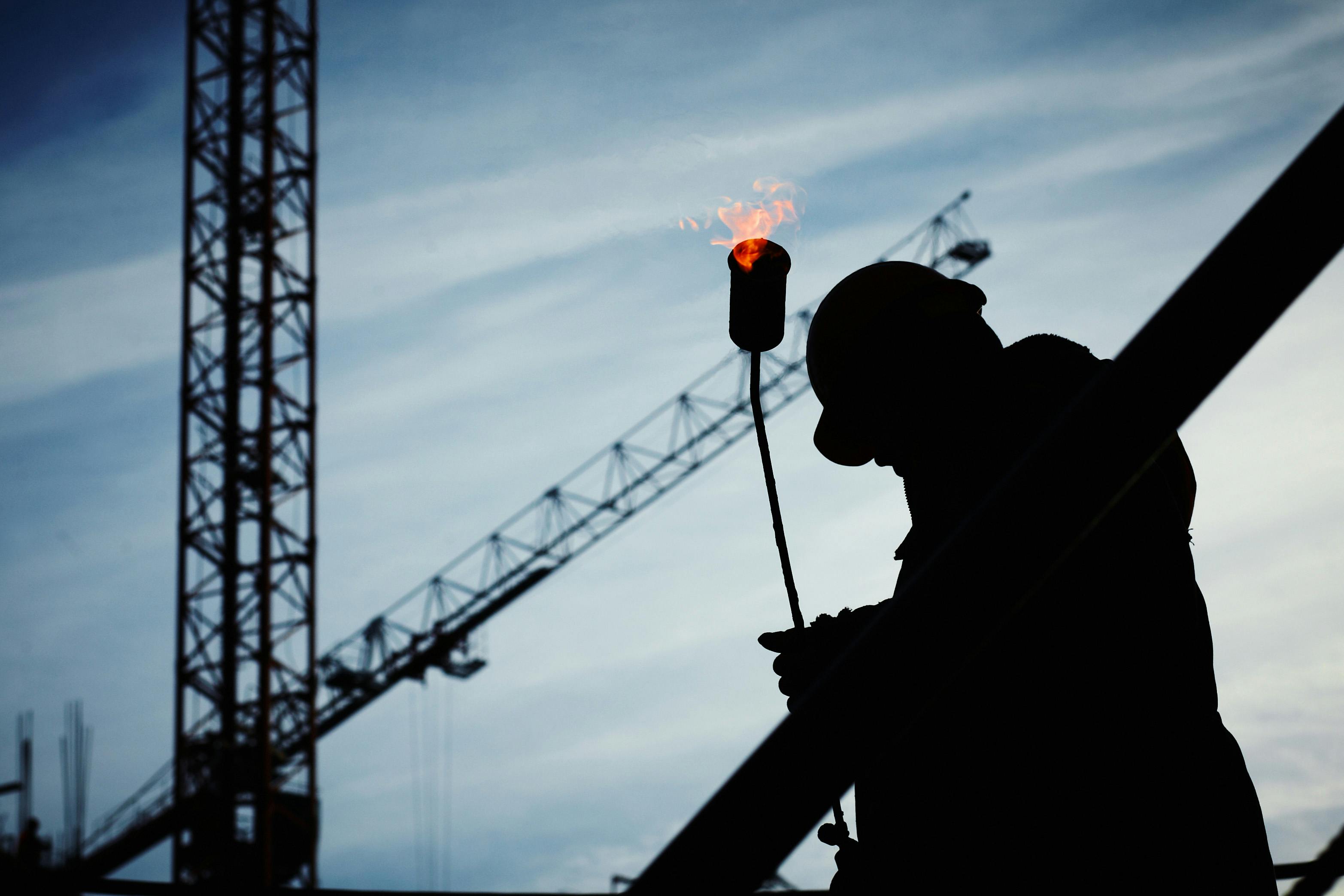 Construction worker silhouette with cranes